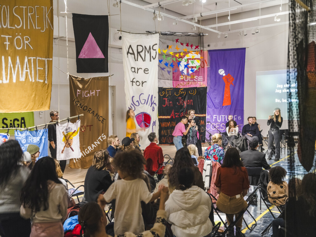 singing karaoke with large audience in gallery space