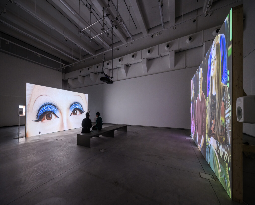 Two-channel video work The Time of Our Lives in ample gallery space with audience watching