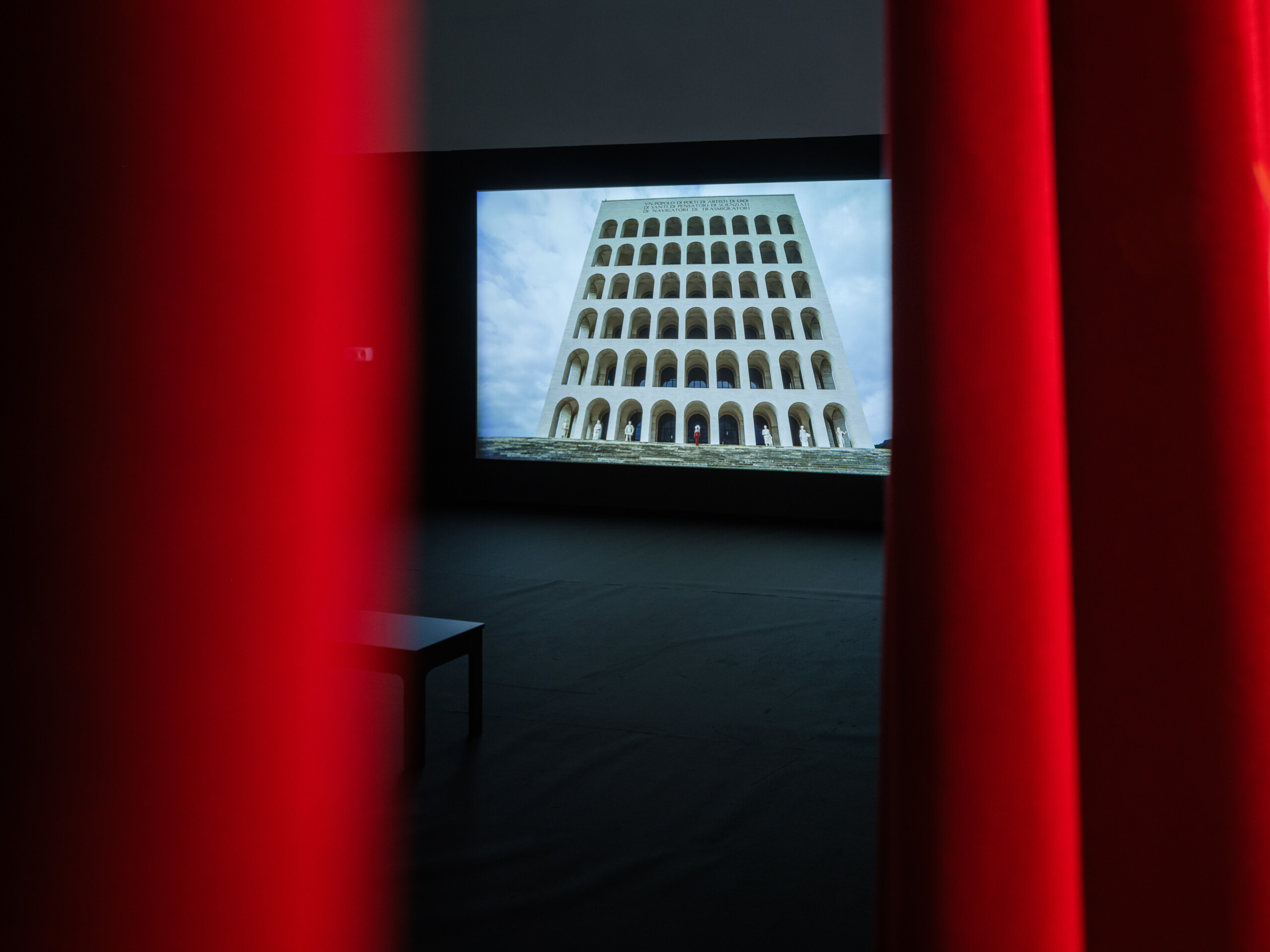 Video still of Palazzo della Civiltà Italiana in the artwork Dreaming the End between two red curtains